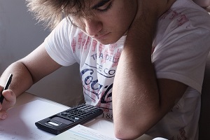 Boy studying using a calculator.