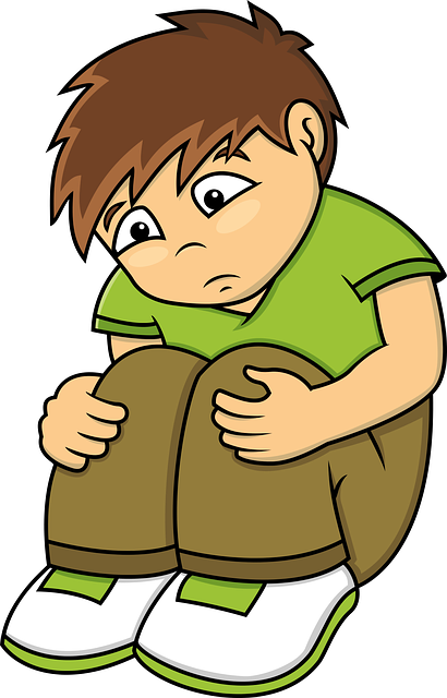 Cartoon image of boy looking sad, sat down hugging his legs.